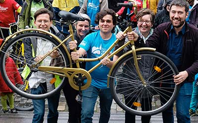 Vier Männer vom radentscheid Aachen heben ein goldenes Fahrrad in die Luft.