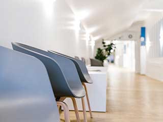 Praxisbild der Radiologie Aachen: graue Stühle, Holzboden, heller Raum